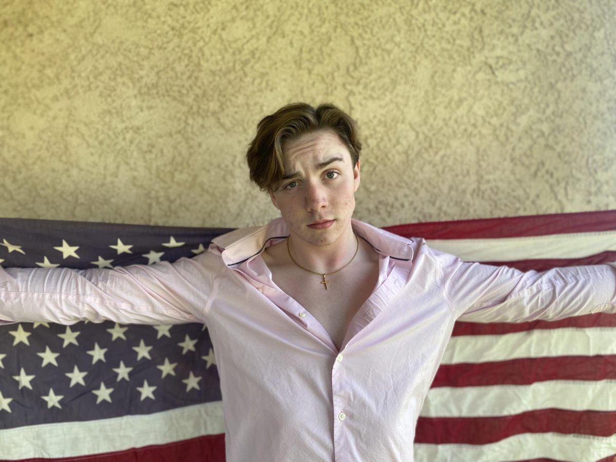 The singularly dashing Ian James spread-eagled before le vieux view, Old Glory, the epitome and climax of our manifest destiny incarnate